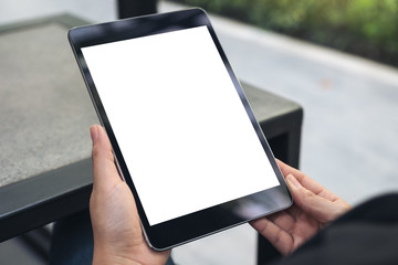Fototapeta na wymiar Mockup image of hands holding black tablet pc with blank white desktop screen