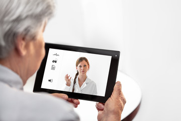 Seniorin hält ein Tablet mit Ärztin und Icons, Telemedizin und virtuelle Sprechstunde