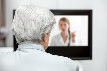 Seniorin in einer digitalen Sprechstunde mit dem Arzt, Telemedizin und virtuelle Diagnostik