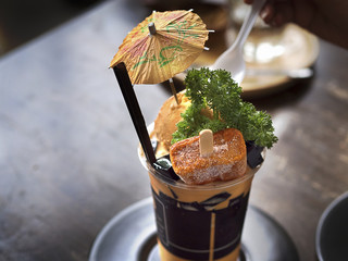Premium Thai tea with milk or Thai tea latte frappe served with Ice cream and mint on wooden table...