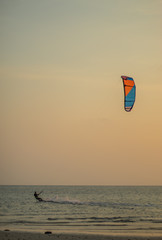 Tourists enjoy Kitesurfer surfing in the sea.