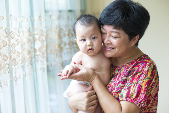 asian grandmother with her baby grandson