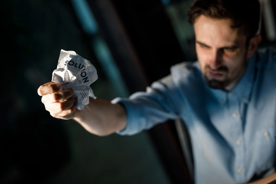 Casual unhappy man in office crumpling paper with word solution failed in results gain