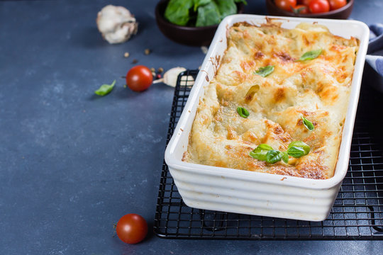 Delicious homemade lasagne with ricotta cheese and spinach on blue stone concreet table background. Vegetarian Food. Italian Food