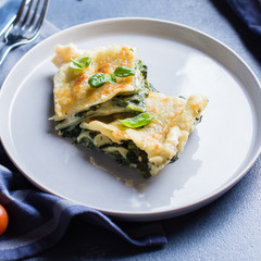 Delicious homemade lasagne with ricotta cheese and spinach on blue stone concreet table background. Vegetarian Food. Italian Food