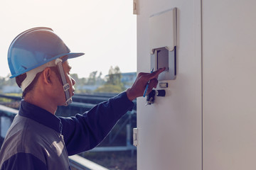 engineer or electrician working on checking and maintenance equipment at green energy solar power...