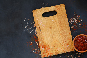 wooden cutting board and salsa sauce in a dipping dish. cooking and food preparing. copy space...