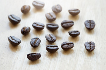 Coffee beans with copy space for text on wood background.