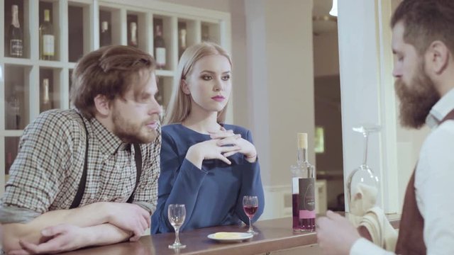Attractive elegant young couple drinking a cocktail at the restaurant. Handsome loving couple flirting in a cafe. Love and romance. Lifestyle concept
