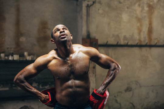 Strong brunette woman boxing indoors.