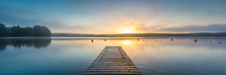 Fototapeta premium Wschód słońca nad jeziorem z mgłą - panorama