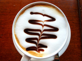 latte art coffee top view white cup on brown wooden table