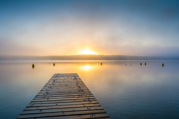 Sonnenaufgang am See mit Steg im Nebel - 208032782