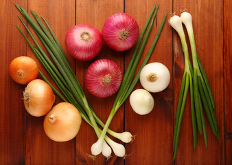 Assorted onion on a wooden background