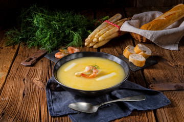 delicious asparagus cream soup with prawns and fresh dill