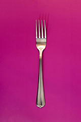 Fork on purple background. Concept.