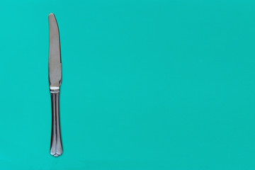 Knife on a bright turquoise background. Copy space for your inscriptions. concept.