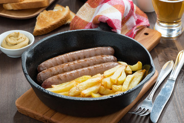 lunch with grilled sausages, French fries, toast and beer