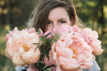Fototapeta premium Florist woman looking over peony flowers