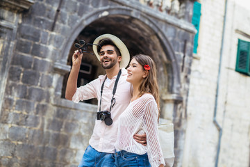 Traveling couple of tourists walking around old town. Vacation, summer, holiday, tourism: concept.