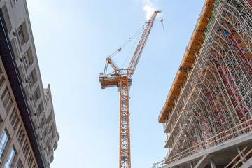 Construction site with crane, scaffold and office building, and a blue sky - Berlin 2018