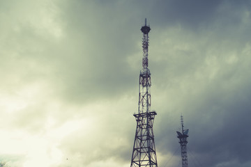 Radio telecommunications tower, Mobile phone tower and old steel pipe in storm clouds. dramatic landscape with cloud storm cloud and metal TV tower.
