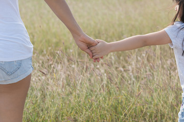 the parent holds the hand of a small child