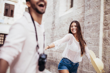 Fototapeta premium Traveling couple of tourists walking around old town. Vacation, summer, holiday, tourism: concept.