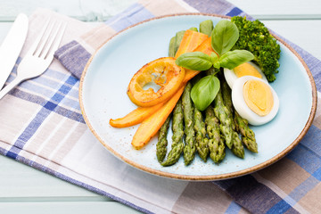 Fried asparagus with broccoli and lemon and carrot.
