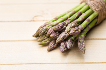 Bunch of fresh asparagus on wooden table.