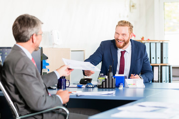 Business manager signing documents at the office