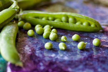 close up of group of peas on  a colored surface