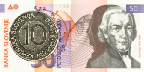 10 slovenian tolar coin against 50 slovenian tolar banknote obverse