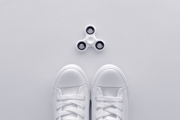 Sneakers and fidget spinner flay lay top view