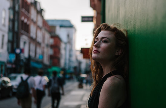 Striking freckled redhead woman looking thoughfully as the sun sets