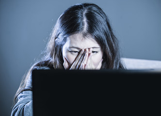 young scared Asian Korean student girl looking depressed and worried studying with laptop computer...