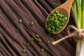 Spring onions also known as salad onions, green onions or scallions on wood background