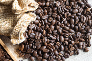 close up Roasted coffee beans in small sack  on wooden table - Powered by Adobe