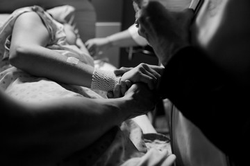 Mother and partner supporting woman in childbirth pain