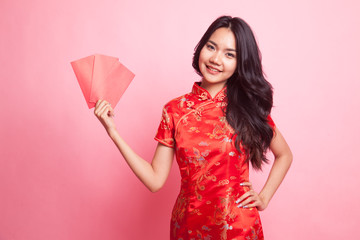 Cute Asian girl in chinese red cheongsam dress with red envelope