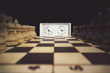 A stopwatch and a chessboard with a game in progress The beginning of the chess game. the first move