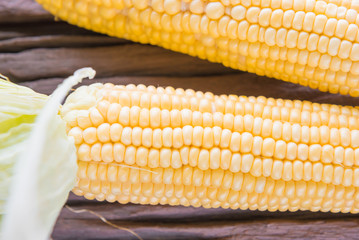 Fresh corn on cobs on rustic wooden table, closeup