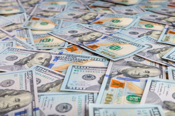 Paper 100 dollar bills spread out on the plane in a chaotic manner