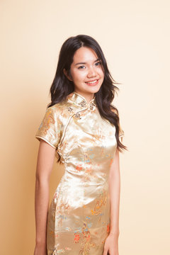 Portrait of Asian girl in golden chinese cheongsam dress