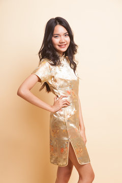 Portrait of Asian girl in golden chinese cheongsam dress