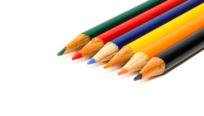Fototapeta premium Coloured small pencils in colours green, red, blue, yellow, orange and black, aligned side by side in a closeup macro photo isolated on a seamless white background with large copy space for text.