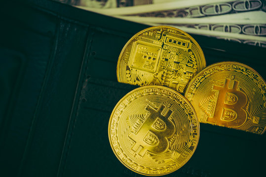 Metal bitcoins in black leather wallet.