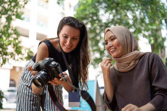 malay girl with tourist showing picture in a camera