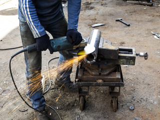 man grinds a steel piece