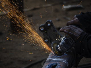  Man grinds a steel piece